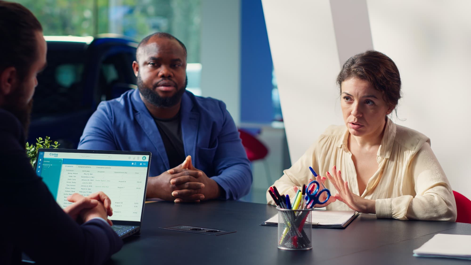 Colleagues in conversation around a boardroom table.