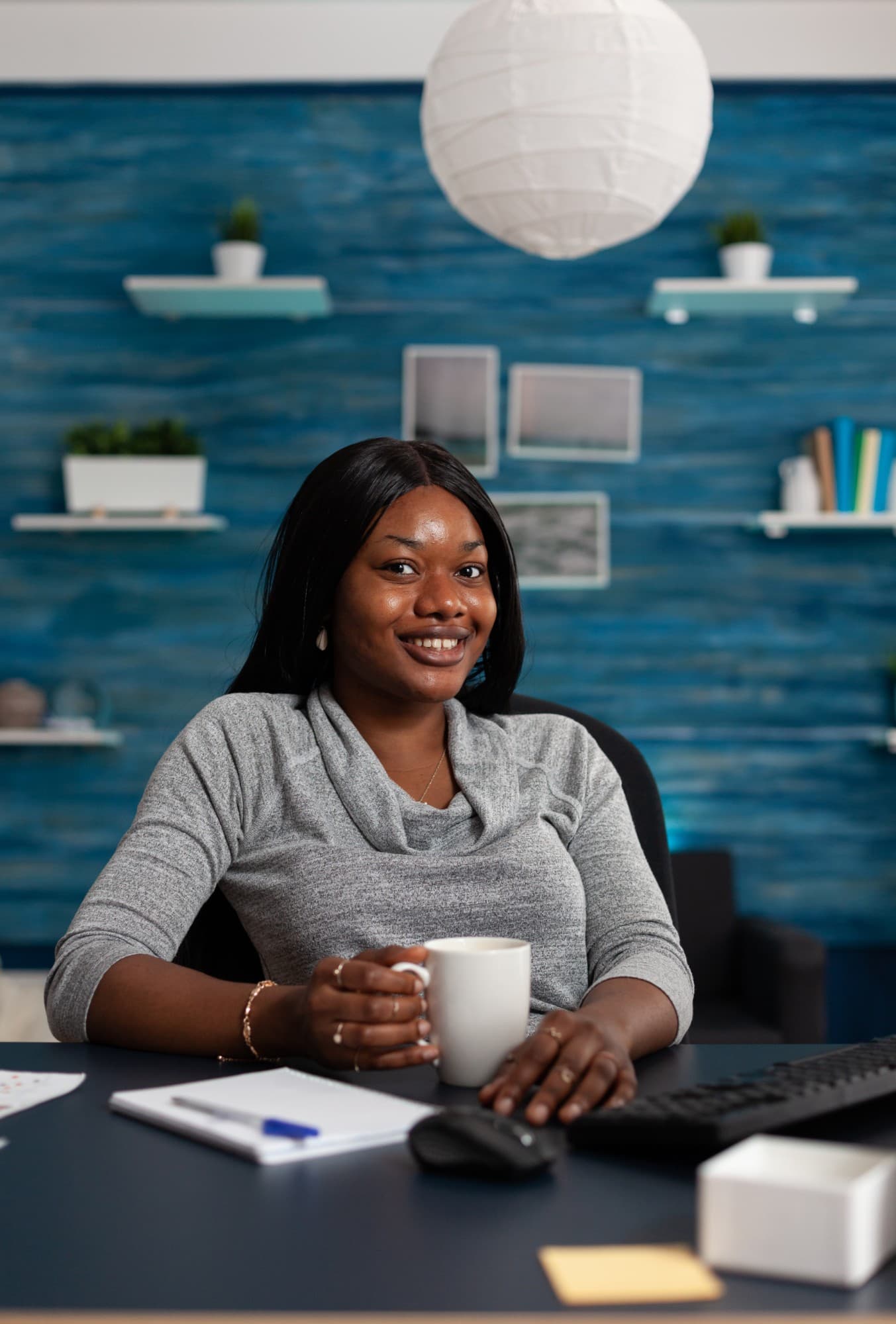 A professional smiling at her desk.